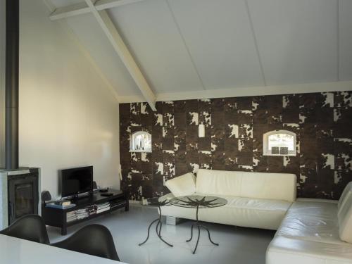 een woonkamer met een witte bank en een zwarte muur bij Lovely Design Countryside Holiday Home in Haaksbergen