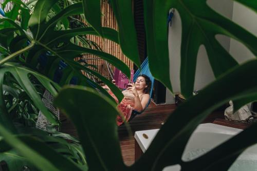 a woman brushing her teeth in front of a mirror at Vila Bambu Ilhabela, Santa Tereza in Ilhabela
