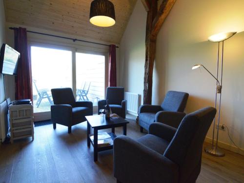 a living room with chairs and a table and a television at Staying in a thatched barn with box bed beautiful view region Achterhoek in Geesteren