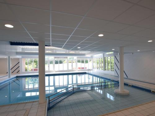 a large swimming pool in a large building at Apartment near the sea in Hollum in Hollum