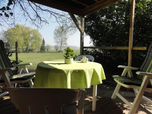 a table with a green table cloth on a patio at Quaint Holiday Home in Koewacht in Nieuwemolen
