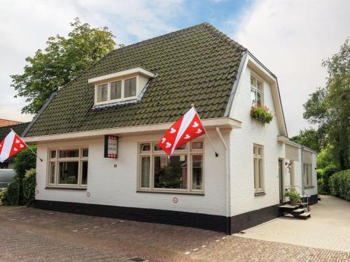 ベルゲンにあるLuxurious apartment walking distance from the pleasant centre of Bergenの白と赤の旗が貼られた小さな白い家