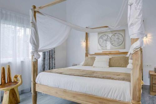 a bedroom with a canopy bed with white sheets at La Oliva Dreams luxury villa in La Oliva
