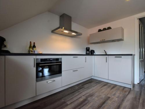 Luxurious apartment in Eibergen في Eibergen: مطبخ بدولاب بيضاء وموقد