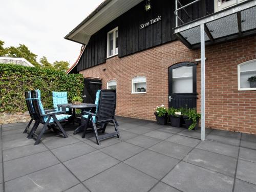 un patio con sillas y una mesa frente a un edificio en Luxurious apartment in Eibergen en Eibergen