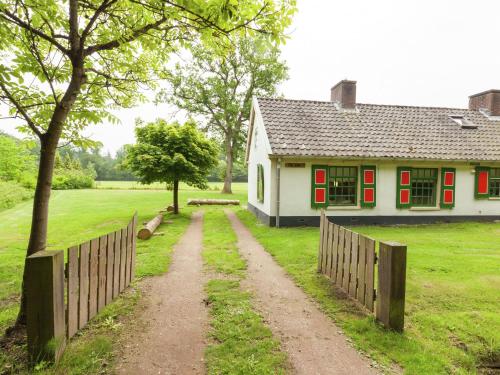 una casa con una valla y un camino de tierra delante en Authentic holiday home near Baarn Utrecht on an estate, en Baarn