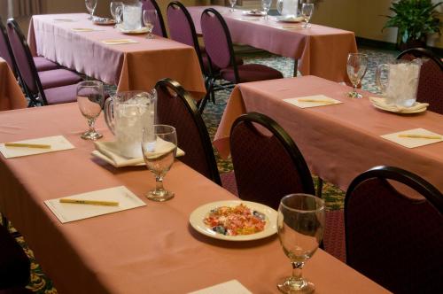 a row of tables with pink table cloths and a plate of food at Meadowlands Plaza Hotel in Secaucus
