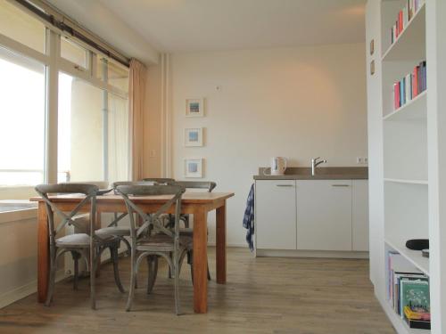 ノールトウェイクにあるCosy apartment in Noordwijk aan Zee with balconyのキッチン(木製テーブル、椅子付)