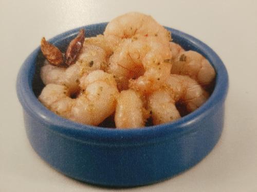 a blue bowl of shrimp sitting on a table at Hotel Martinez Grenay in Grenay