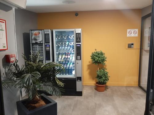 a vending machine with drinks in a room at Hotel Martinez Grenay in Grenay
