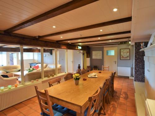 ein Esszimmer mit einem großen Holztisch und Stühlen in der Unterkunft Quaint Farmhouse near River in Oosterwijk in Leerdam