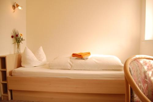 a bed with a yellow towel on top of it at Landgasthof "Am Park" in Crottendorf