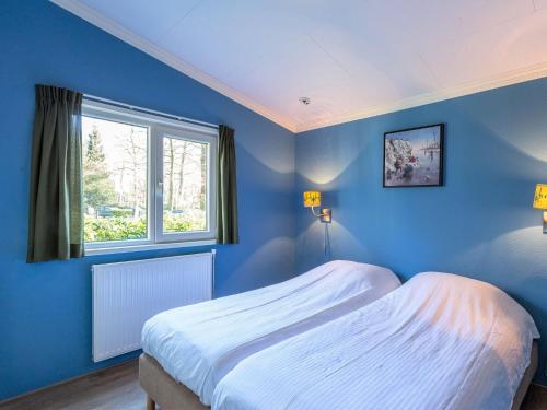 a blue bedroom with a bed and a window at Unique Stay with Cozy Alcoves in De Bult
