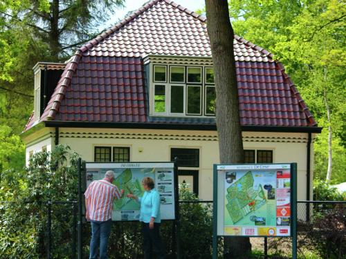 a man and a woman standing in front of a house at Forest Lodge in De Bult near Pool & Restaurant in De Bult