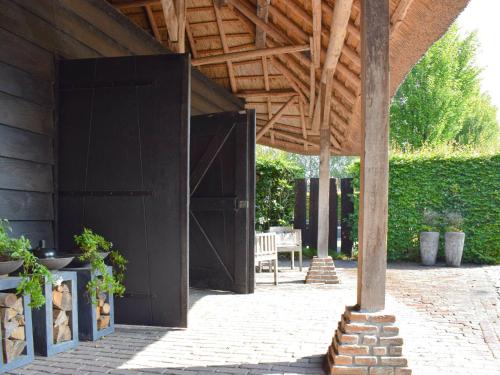 Alphen的住宿－Unique holiday home with a hot tub，一座大型黑色建筑,设有木屋顶