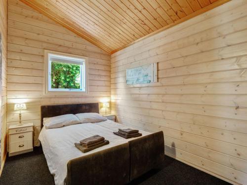sypialnia z łóżkiem w drewnianym pokoju w obiekcie Luxurious Chalet in Guelders by the Forest w mieście Hulshorst