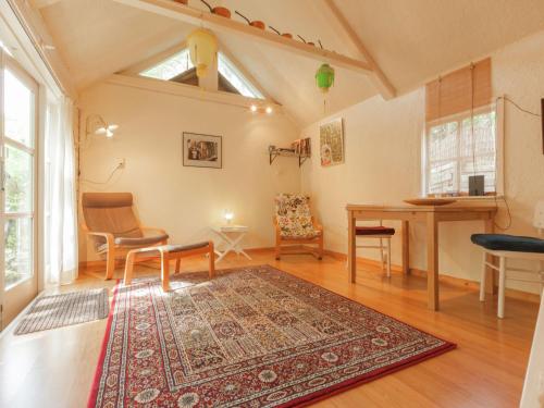 een woonkamer met een tafel en stoelen en een tapijt bij In the middle of the Gooise landscape in Huizen