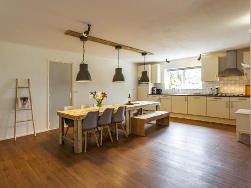 eine Küche und ein Esszimmer mit einem Holztisch und Stühlen in der Unterkunft Charming Holiday Home near Beach in Meliskerke in Meliskerke