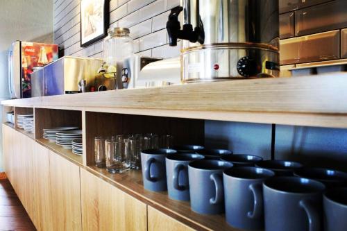 a row of blue coffee cups sitting on a shelf in a kitchen at Мини отель Muritz in Tolyatti