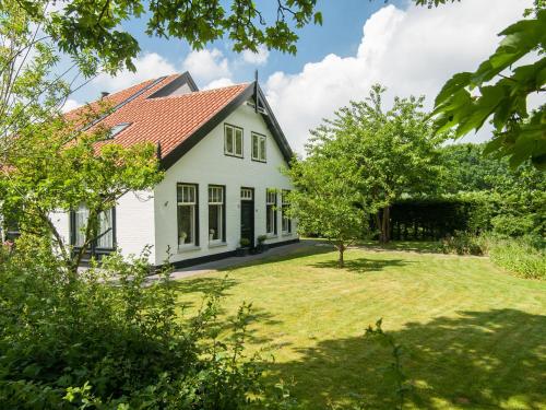 Casa blanca con techo rojo en Attractive countryside holiday home in quiet, en Schoorl