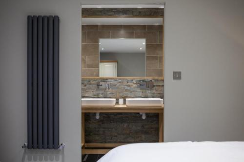 a bathroom with two sinks and a mirror at The Venue Serviced Apartments in Huddersfield