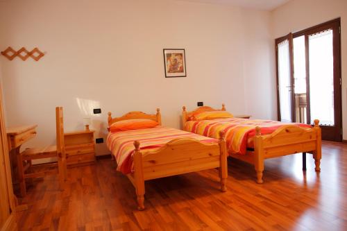 Duas camas num quarto com pisos em madeira em Sentiero Valinis em Fanna