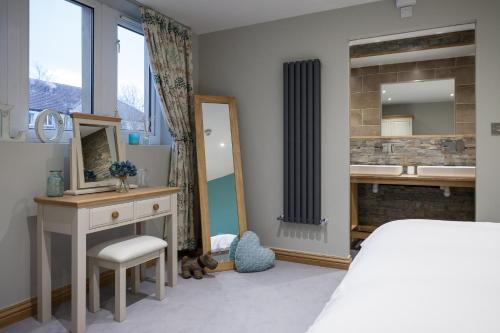 a bedroom with a bed and a sink and a mirror at The Venue Serviced Apartments in Huddersfield