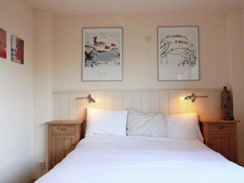エグモント・アーン・デン・フフにあるSpacious Holiday Home with Gardenのベッドルーム1室(白い大型ベッド1台、ナイトスタンド2台付)