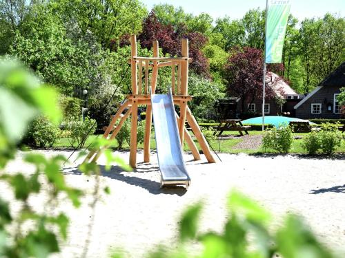 a playground with a slide in the sand at Chalet in Netherlands near Forest & Water in Dalfsen