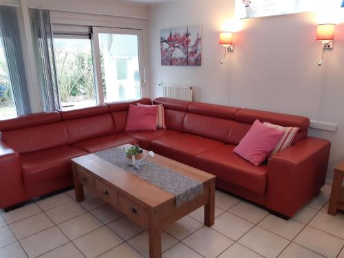 um sofá vermelho numa sala de estar com uma mesa de centro em Superb holiday home near the Lauwersmeer em Oostmahorn
