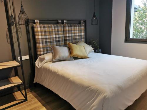 a bedroom with a large white bed with pillows at Apartaments Agulles de Montserrat in Monistrol