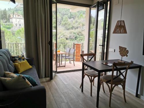 a living room with a couch and a table and chairs at Apartaments Agulles de Montserrat in Monistrol