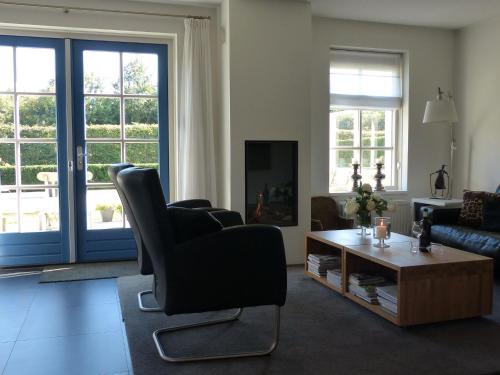 スコールルにあるLuring Holiday Home in Callantsoog near the Seaのリビングルーム(黒い椅子、テーブル付)