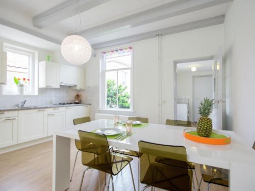 a white kitchen with a white table and chairs at Beautiful house in the center of Harlingen in Harlingen