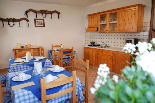 a dining room with a table and chairs and a kitchen at Sentiero Valinis in Fanna