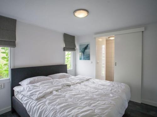 a white bed in a bedroom with a window at Terrace Apartment in Kattendijke in Kattendijke