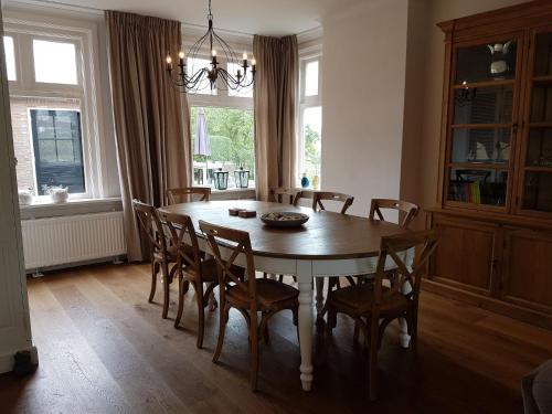 a dining room with a wooden table and chairs at Spacious Farmhouse in IJzendijke with Garden in Schoondijke