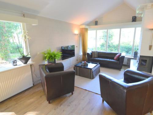 sala de estar con muebles de cuero y TV en Modern Holiday Home in Haaksbergen with Garden, en Haaksbergen