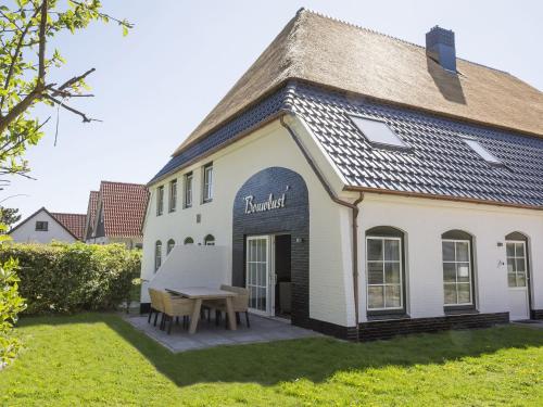 a white building with a table in the yard at Apartment with Private Terrace Garden in De Cocksdorp Texel in De Cocksdorp