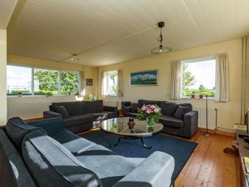 een woonkamer met banken en een tafel bij Peaceful vacation home in Finsterwolde with wide views in Finsterwolde