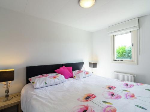 KattendijkeにあるModern Holiday Home in Kattendijke with a Gardenのベッドルーム1室(ピンクの枕が付くベッド1台、窓付)