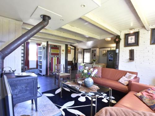 een woonkamer met een bank en een open haard bij Attractive miller s house in t Zand with a beautiful view in Oudesluis