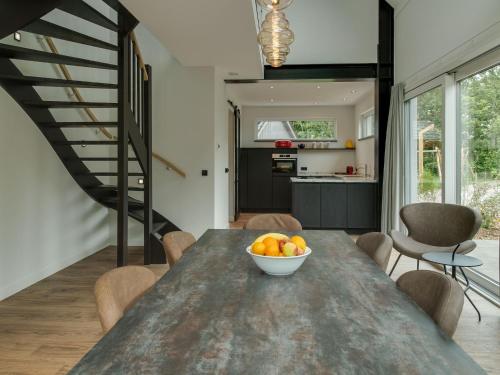 a kitchen and dining room with a table with a bowl of fruit at Holiday home on island Texel with sauna in Westermient