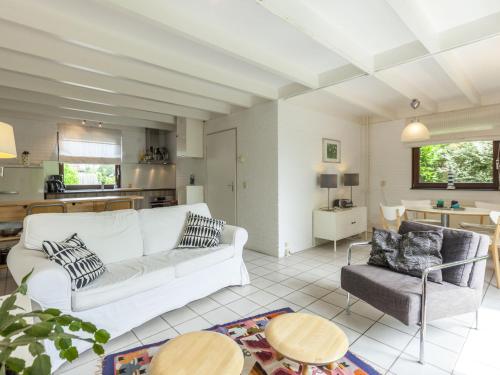 a living room with a white couch and a table at Lovely holiday home in Wolphaartsdijk in Wolphaartsdijk