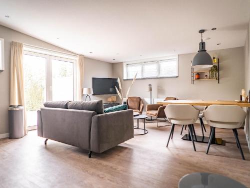 a living room with a couch and a table at Comfortable Farmhouse in De Cocksdorp near Sea in De Cocksdorp