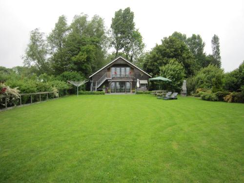 een grote groene tuin met een groot huis bij Luxury Holiday Home In Noordbeemster in Noordbeemster