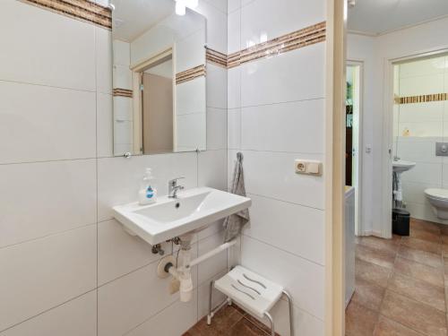 a white bathroom with a sink and a toilet at Farmhouse in Eastermar near De Leijen River in Hoogzand