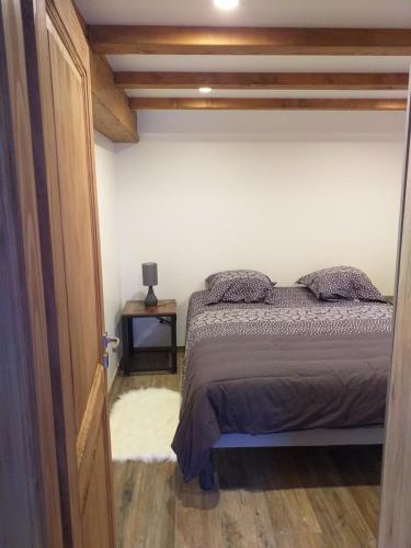 een slaapkamer met een bed in een kamer met houten plafonds bij Cocon de St Pierre in Sainte-Marie-aux-Mines