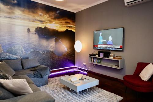 a living room with a couch and a tv at Our Dream Downtown Experience by AnaLodges in Funchal