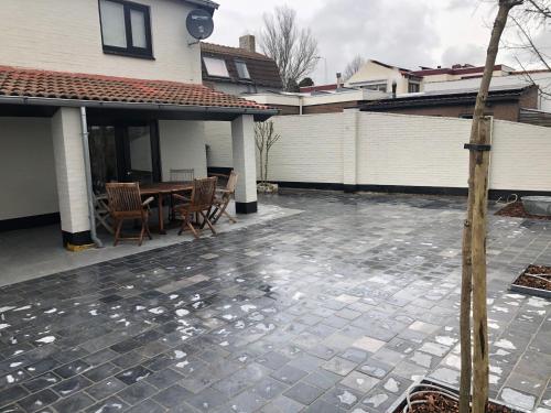 a patio with a table and chairs in a house at Graafjansdijk B Vakantiehuis met 3 slaapkamers net over de Belgische grens in Westdorpe